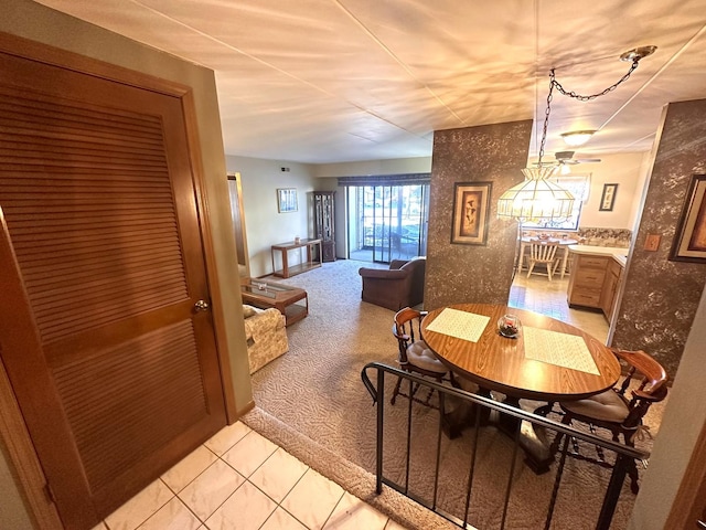 carpeted dining area with ceiling fan