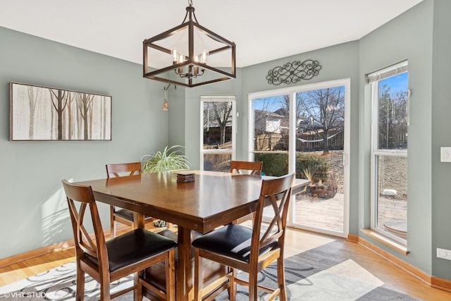 dining space featuring light hardwood / wood-style floors and a notable chandelier