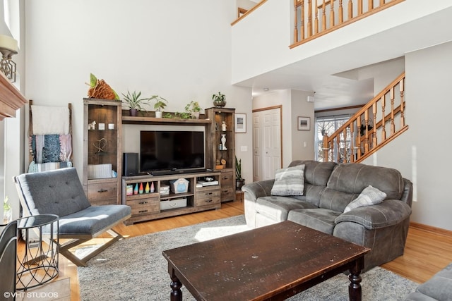 living room with a towering ceiling and light hardwood / wood-style floors