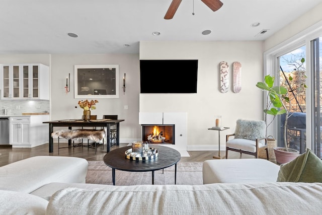 living room featuring dark wood-type flooring and ceiling fan