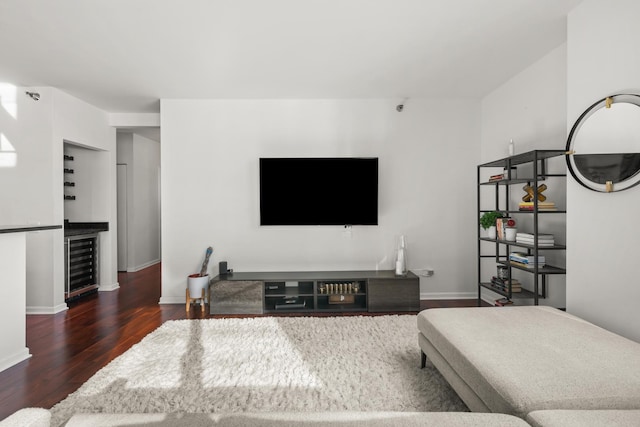 living room with dark wood-type flooring, bar area, and beverage cooler