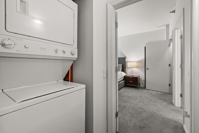 washroom with light colored carpet and stacked washer and dryer