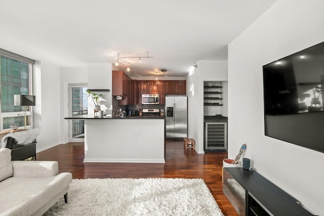 kitchen featuring beverage cooler, dark hardwood / wood-style flooring, stainless steel appliances, and tasteful backsplash