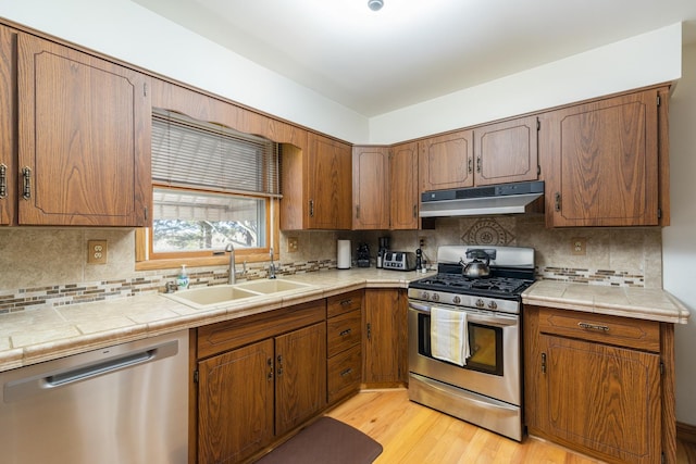 kitchen featuring tasteful backsplash, sink, tile countertops, and stainless steel appliances