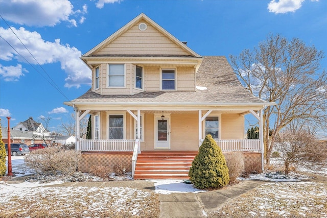 view of front of property featuring covered porch and a shingled roof