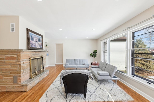 living room with a fireplace and light wood-type flooring