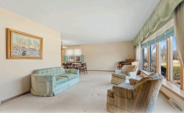 carpeted living room featuring a notable chandelier