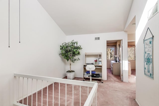 hall featuring carpet floors and vaulted ceiling