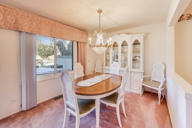 carpeted dining room featuring an inviting chandelier