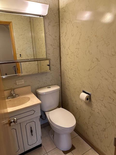 bathroom featuring tile patterned flooring, vanity, and toilet