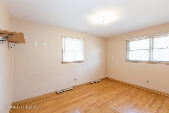 unfurnished room with light wood-style flooring, baseboards, and visible vents