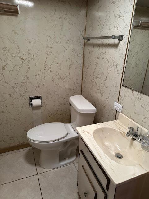 bathroom with vanity, tile patterned flooring, and toilet