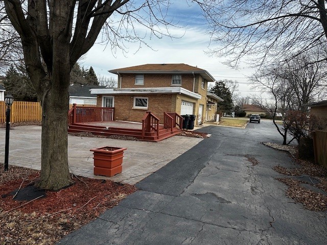 view of home's exterior with a garage and a deck