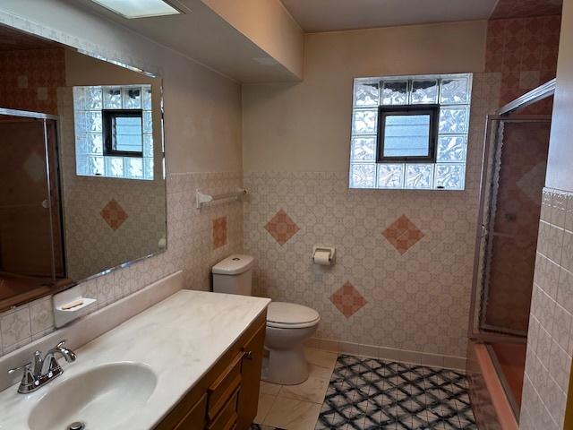 bathroom featuring vanity, an enclosed shower, and a wealth of natural light