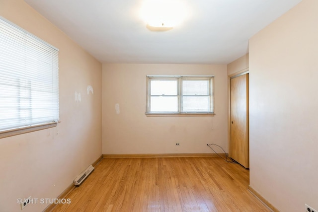 spare room featuring baseboards and light wood-style floors