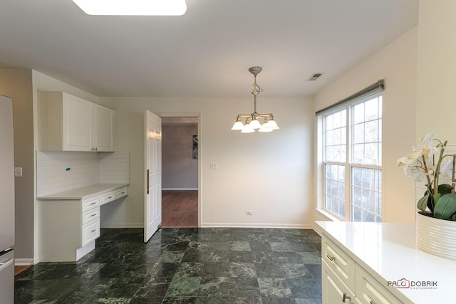 kitchen featuring an inviting chandelier, white cabinetry, tasteful backsplash, and decorative light fixtures