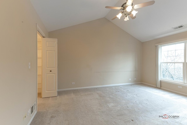 carpeted spare room featuring ceiling fan and vaulted ceiling