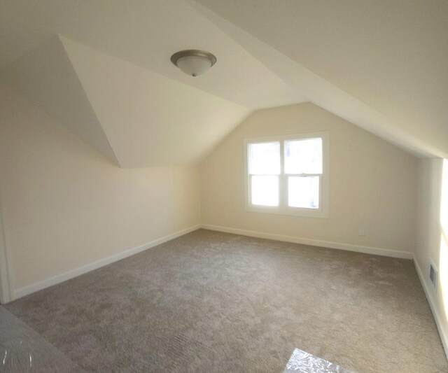 bonus room featuring carpet and vaulted ceiling