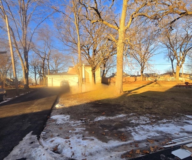 yard covered in snow featuring a garage