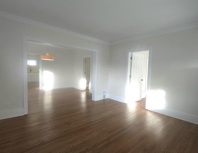 unfurnished room featuring dark wood-type flooring and ornamental molding