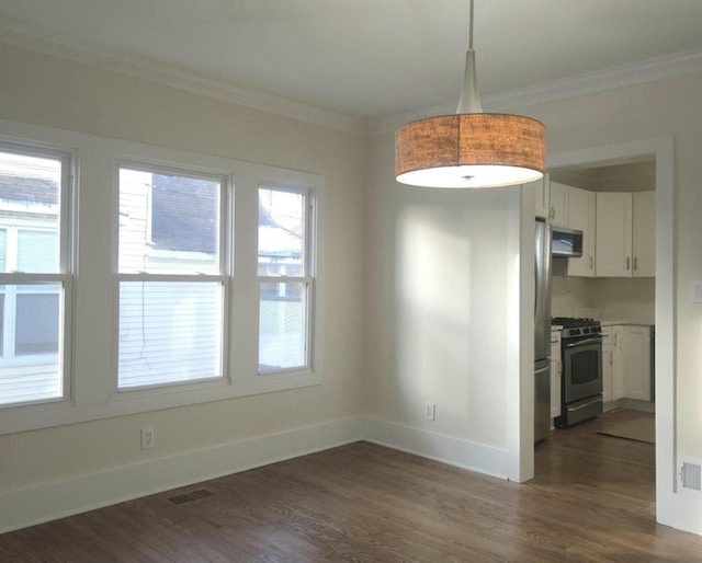 unfurnished dining area featuring dark wood-type flooring and crown molding