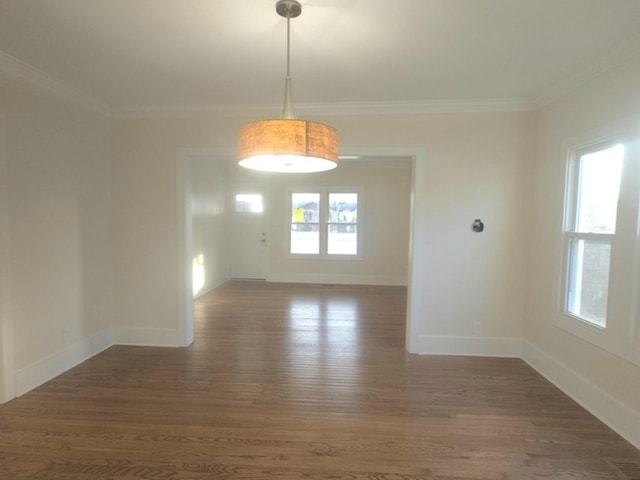 unfurnished room with dark wood-type flooring, a wealth of natural light, and crown molding