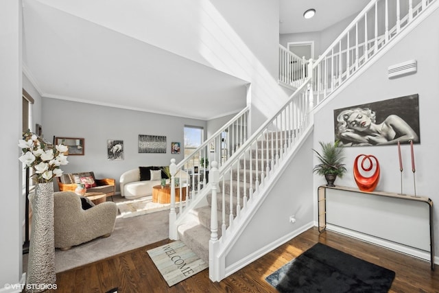 stairs with hardwood / wood-style flooring and ornamental molding