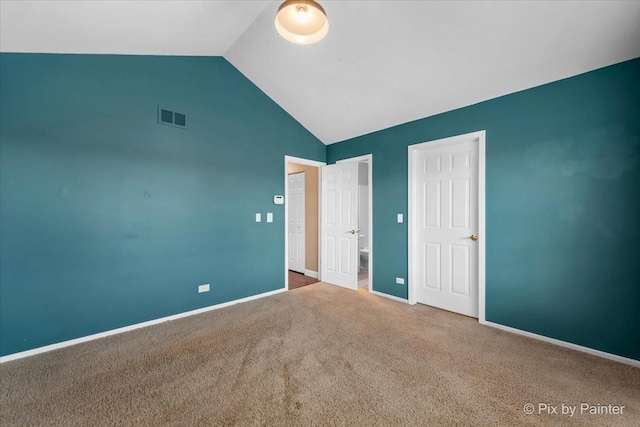 unfurnished bedroom featuring carpet floors and vaulted ceiling