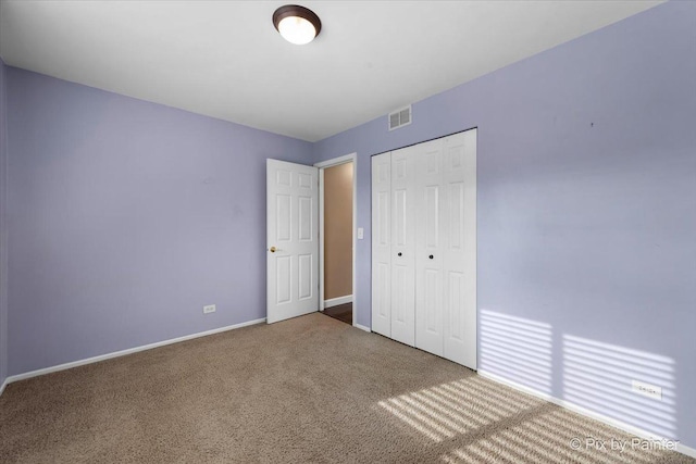 unfurnished bedroom featuring a closet and carpet flooring