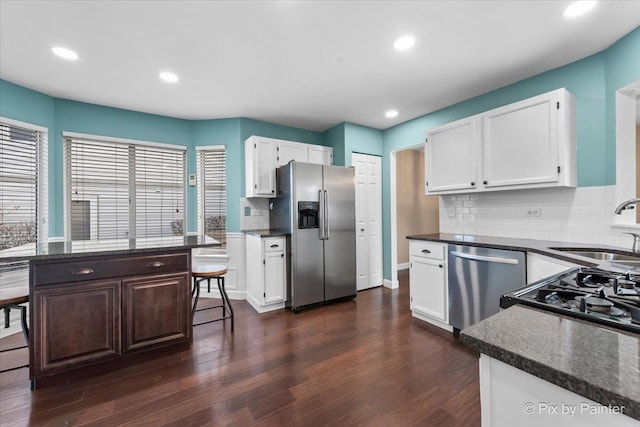 kitchen with decorative backsplash, sink, white cabinetry, stainless steel appliances, and dark hardwood / wood-style flooring