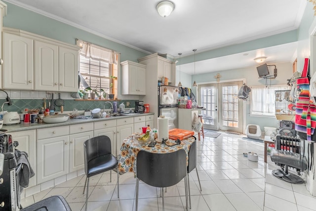 kitchen featuring tasteful backsplash, pendant lighting, sink, appliances with stainless steel finishes, and ornamental molding