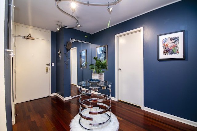 foyer with hardwood / wood-style floors and track lighting