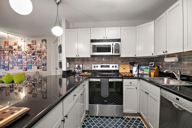 kitchen featuring white cabinetry, appliances with stainless steel finishes, sink, and hanging light fixtures