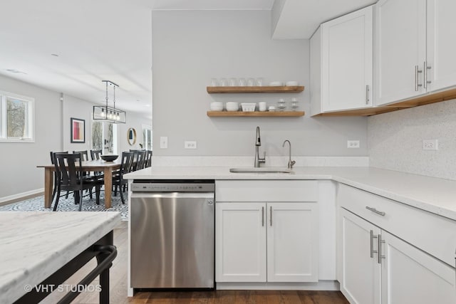 kitchen with stainless steel dishwasher, sink, decorative light fixtures, backsplash, and white cabinets