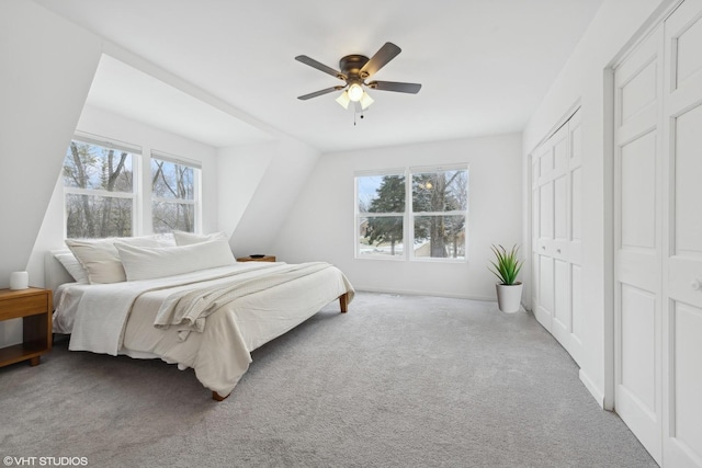 carpeted bedroom featuring ceiling fan and two closets