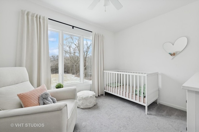 bedroom featuring ceiling fan, carpet floors, and a crib