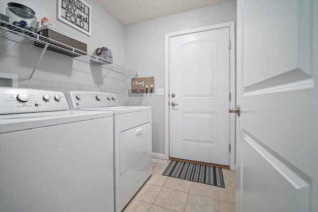 laundry room featuring separate washer and dryer and light tile patterned floors