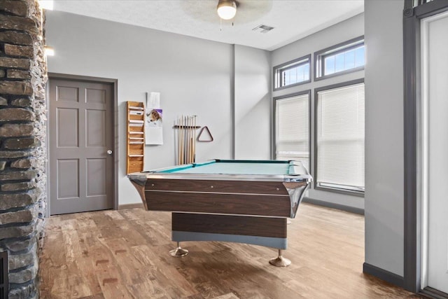 game room with a textured ceiling, light wood-type flooring, and billiards