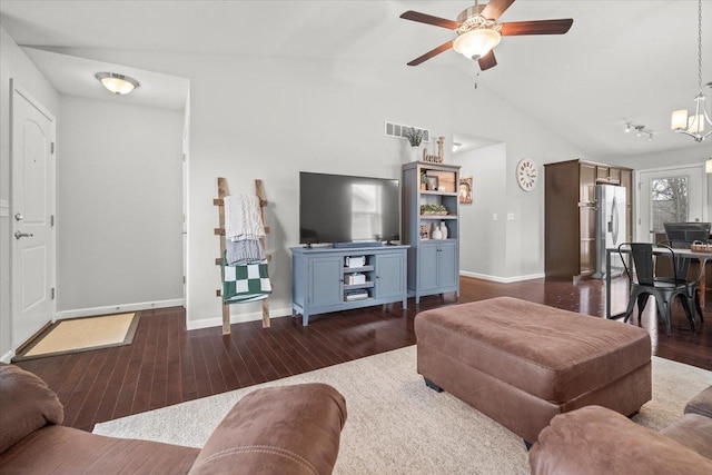 living room with ceiling fan with notable chandelier, vaulted ceiling, and dark hardwood / wood-style floors