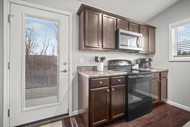 kitchen with dark wood-type flooring, black range with electric stovetop, and dark brown cabinets