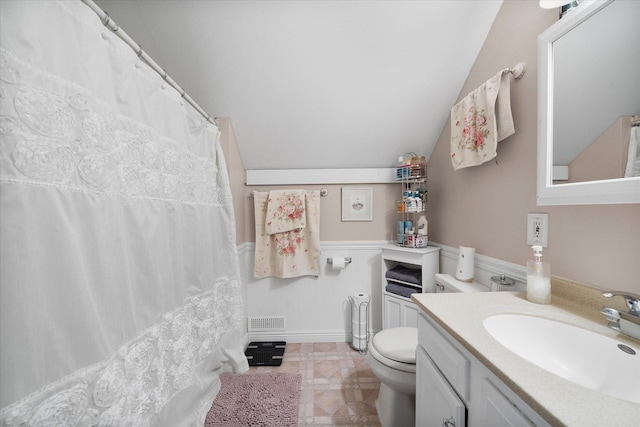 bathroom with vanity, toilet, and vaulted ceiling