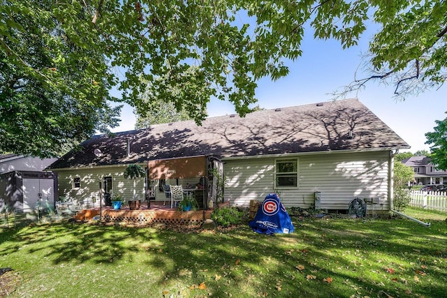 rear view of property featuring a wooden deck and a lawn