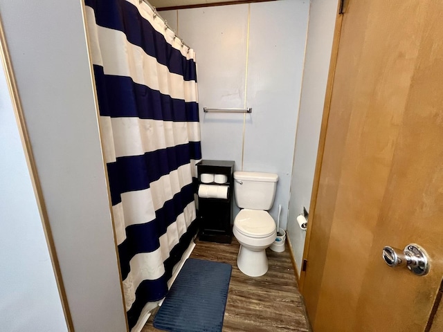 bathroom featuring walk in shower, wood-type flooring, and toilet