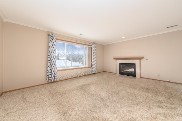 unfurnished living room with a tiled fireplace, ornamental molding, and carpet