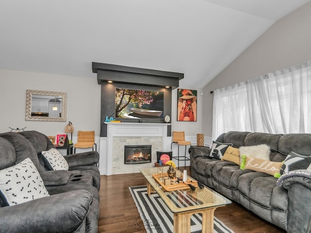 living room featuring vaulted ceiling, dark wood-type flooring, and a tiled fireplace