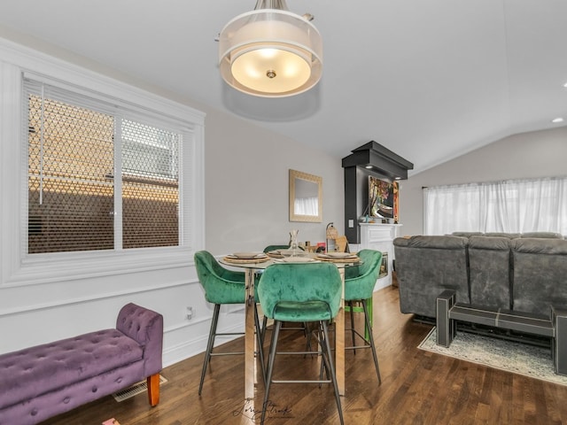 dining room with lofted ceiling and dark wood-type flooring