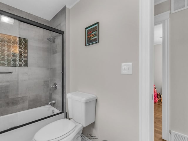 bathroom featuring toilet and enclosed tub / shower combo