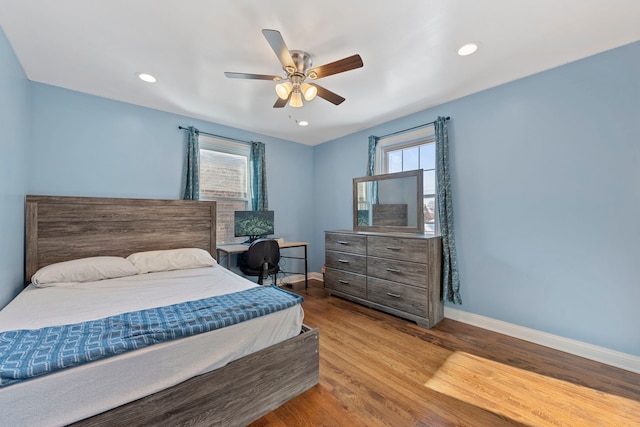 bedroom featuring multiple windows, ceiling fan, and light wood-type flooring