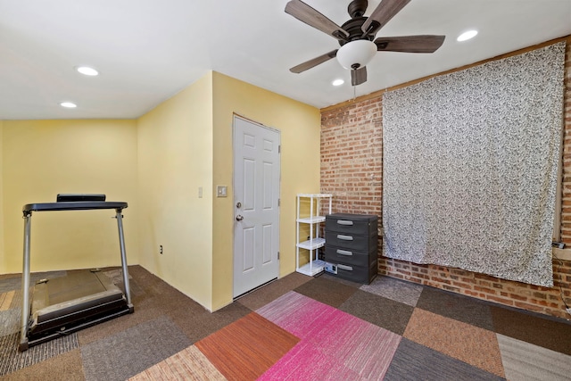 workout room featuring ceiling fan and dark colored carpet