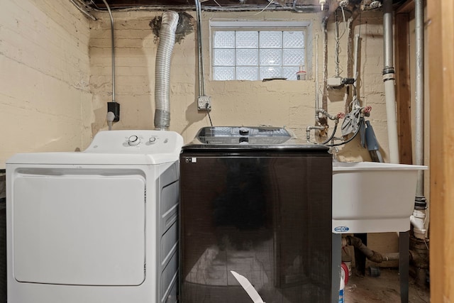 laundry area with separate washer and dryer and sink